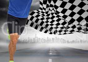 Male runner legs on road with skyline against storm and checkered flag