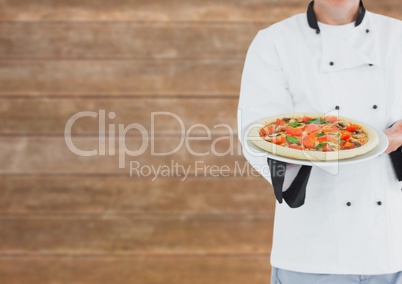 Chef showing the pizza. Blurred wood background