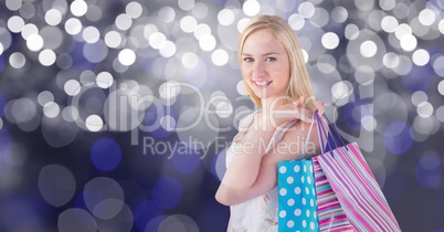 Portrait of woman carrying shopping bags over bokeh