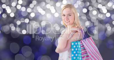 Portrait of woman carrying shopping bags over bokeh