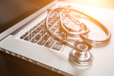 Medical Stethoscope Resting on Laptop Computer Keyboard.