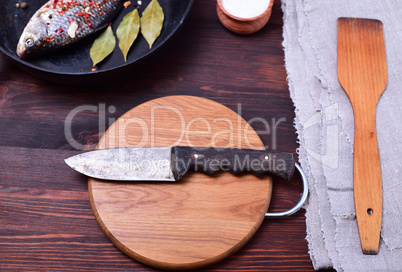 Kitchen knife on a circular cutting wooden board