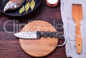 Kitchen knife on a circular cutting wooden board