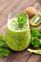 Fresh green kiwi smoothie with mint and honey, healthy organic drink on wooden table