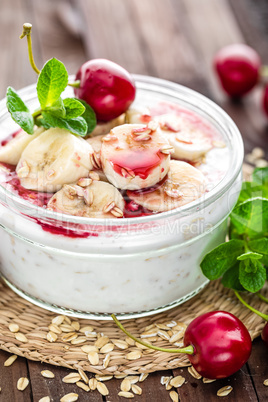 Fresh yogurt with cherry, banana and oats, healthy breakfast