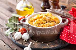 Stewed cabbage with meat on dark rustic wooden background