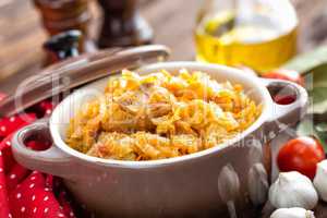 Stewed cabbage with meat on dark rustic wooden background