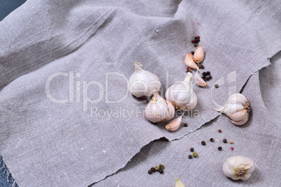 Garlic in husk on gray fabric, top view