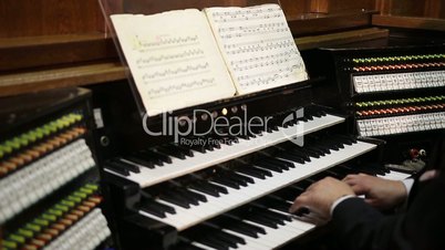 Close up view of organist playing pipe organ.