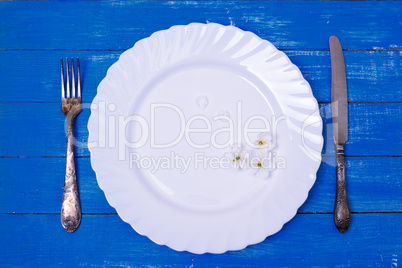 White empty plate and vintage iron cutlery