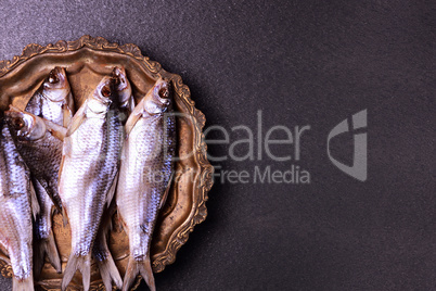 Dried in salt fish ram on scales on a copper tray,