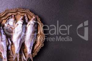 Dried in salt fish ram on scales on a copper tray,