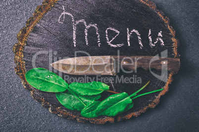 Old kitchen knife lies on a black wooden board