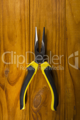 multitool pliers on wooden background