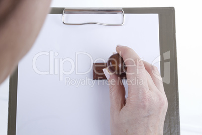 Hands with sheet of paper on clipboard