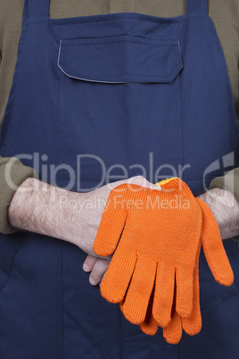 Man in working clothes with gloves.