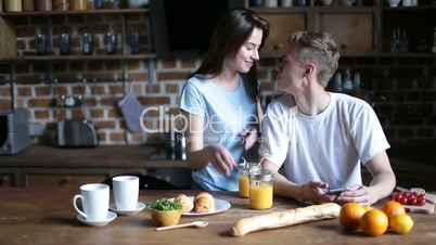 Young couple enjoying breakfast in kitchen