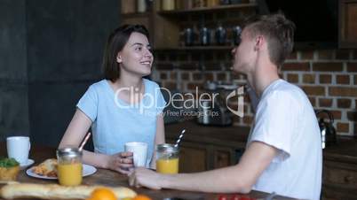 Loving couple having breakfast in modern kitchen