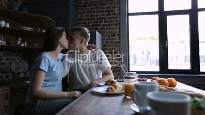 Happy young beautiful couple kissing in kitchen