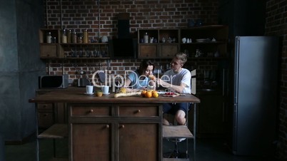 Romantic couple sharing croissant in kitchen