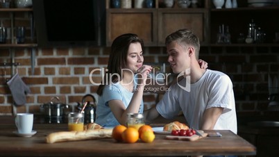Cute couple having breakfast together at home