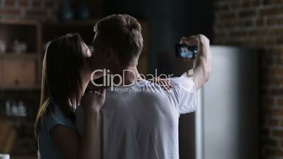 Couple making self-portrait on smart phone at home