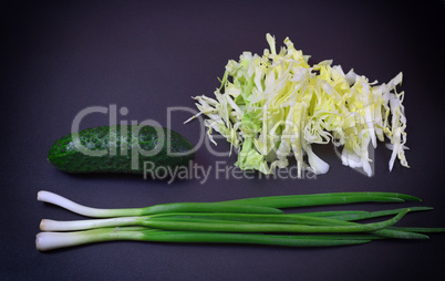 bunch of green onions, cucumber and sliced white cabbage