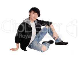 Young Asian man sitting on floor.