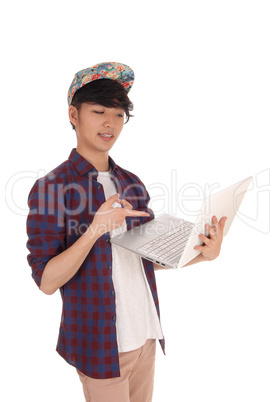 Asian teenager pointing at his laptop.