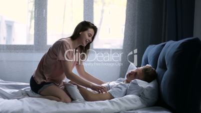 Romantic couple lying on bed and being passionate