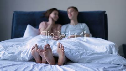 Close-up human feet together under the blanket