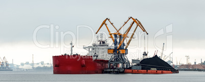 Large red cargo ship loading