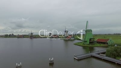 Riverside windmills and green field, aerial view