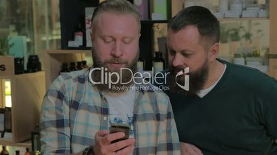 Two bearded men using smart phone