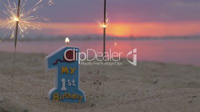 One year old baby boy birthday candle on the beach