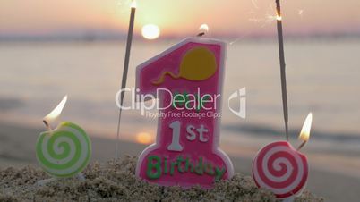 Baby girl first birthday candle on the beach