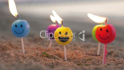 Burning smiley candles on the beach