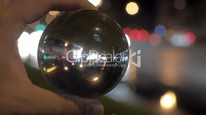 Looking at night city through glass ball