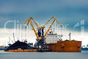 Large orange cargo ship loading
