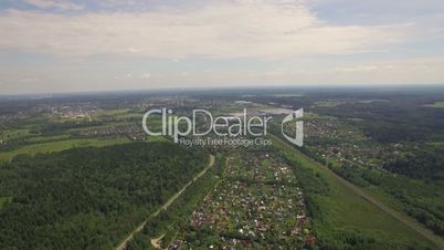 View of forest, country houses against blue sky with clouds at summer, Moscow, Russia