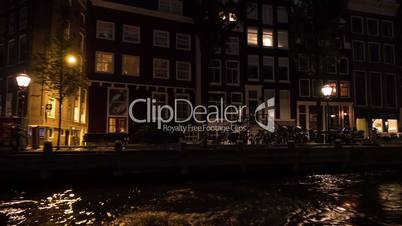 Timelapse view of cityscape during river cruise at night, Amsterdam, Netherlands