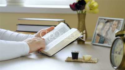 Woman reading the Holy Bible before taking communion