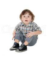 Little three year boy sitting on floor.