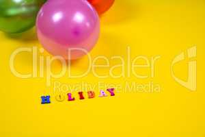 Abstract yellow background with holiday sign and balloons