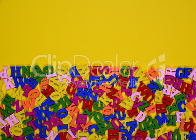 Wooden multicolored letters of the English alphabet on a yellow