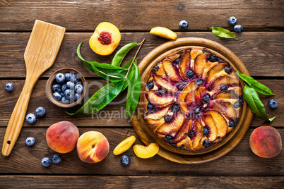 Peach cheese cake or pie with fresh blueberry on wooden rustic background, top view, closeup