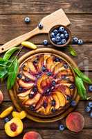 Peach cheese cake or pie with fresh blueberry on wooden rustic background, top view, closeup