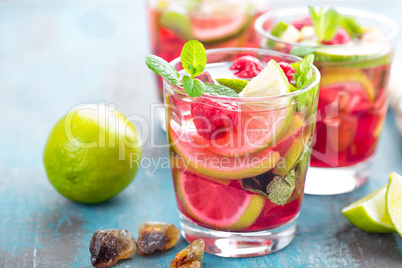 Refreshing mint cocktail mojito with rum, lime and raspberry, cold drink or beverage