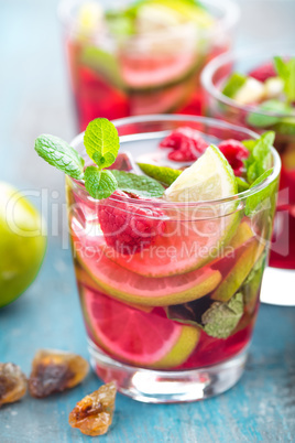 Refreshing mint cocktail mojito with rum, lime and raspberry, cold drink or beverage