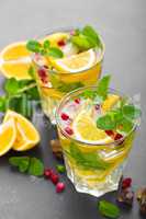 Lemon mojito cocktail with fresh mint and pomegranate, cold refreshing summer drink or beverage with ice